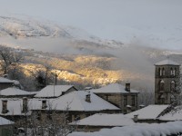 Snow white roofs of a traditional stone village in the Zagori area in Greece