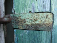 Old iron strap door hinge on an weather tormented door in the village of Vradeto in the National Park of Pindus, Greece