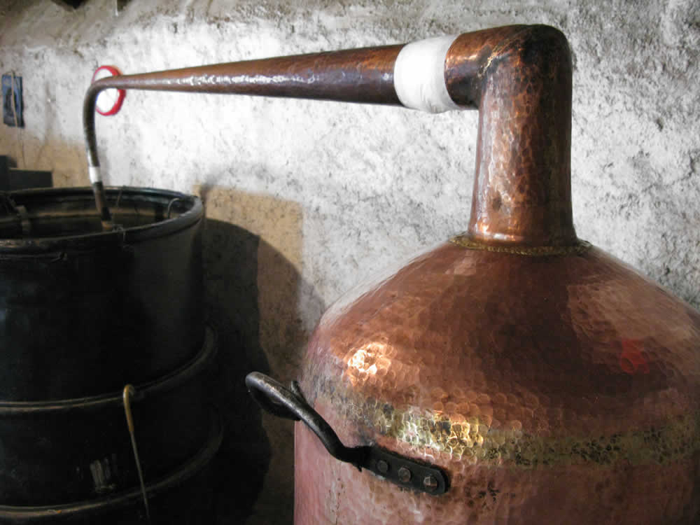 The vapors containing the alcohol and some water rise up to the top of the still and the captured steam is drawn off into the lyne arm