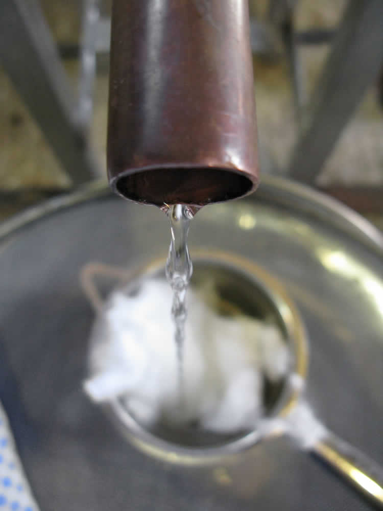 After about an hour, the first drops appear from the spout of the condenser